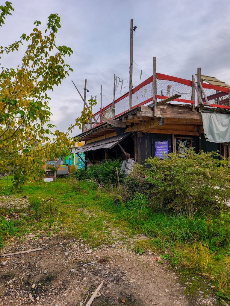 reUnion Seitenansicht Bauarbeiten Oktober 2025 - alte Fensterläden aus Holz, die entfernt werden müssen. Viel Grün drum herum.