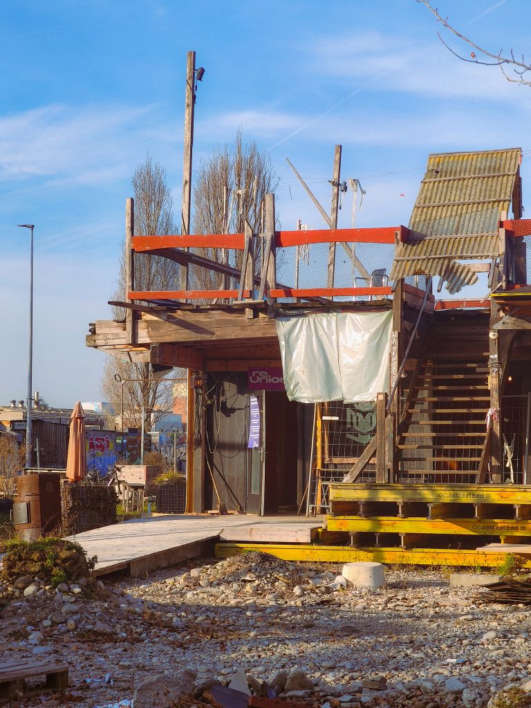 reUnion Frontansicht Bauarbeiten Januar 2026 - noch viel Arbeit zu tun, überall hängen Planen und liegt Holz herum