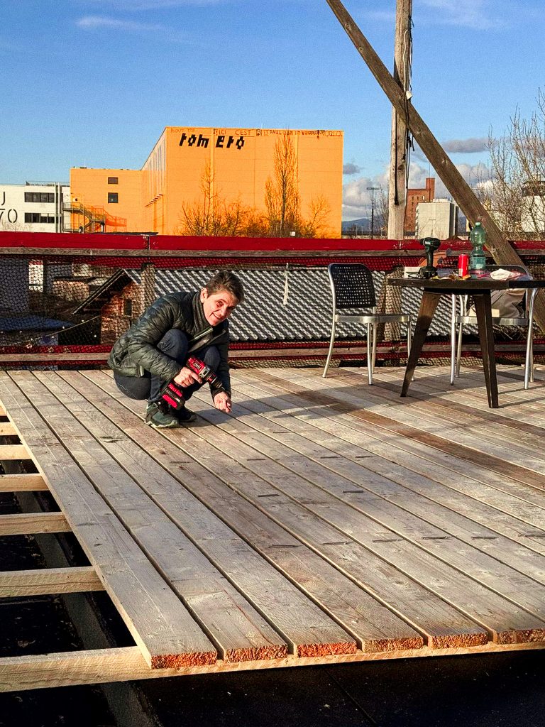 Helferin schraubt Latten auf unserer Dachterrasse fest